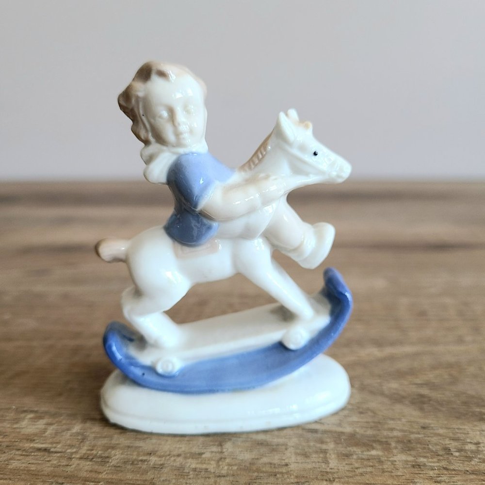 Vintage porcelain ceramic girl's on rocking horse figurine.